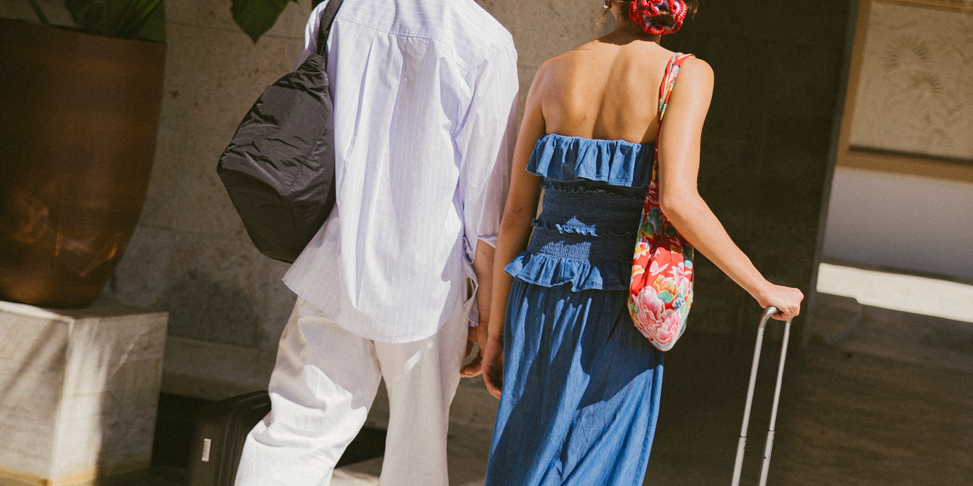 a man and woman walking with luggage