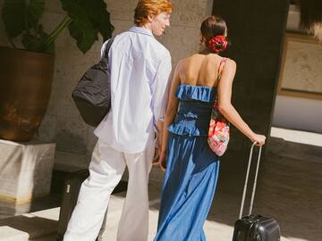 a man and woman walking with luggage