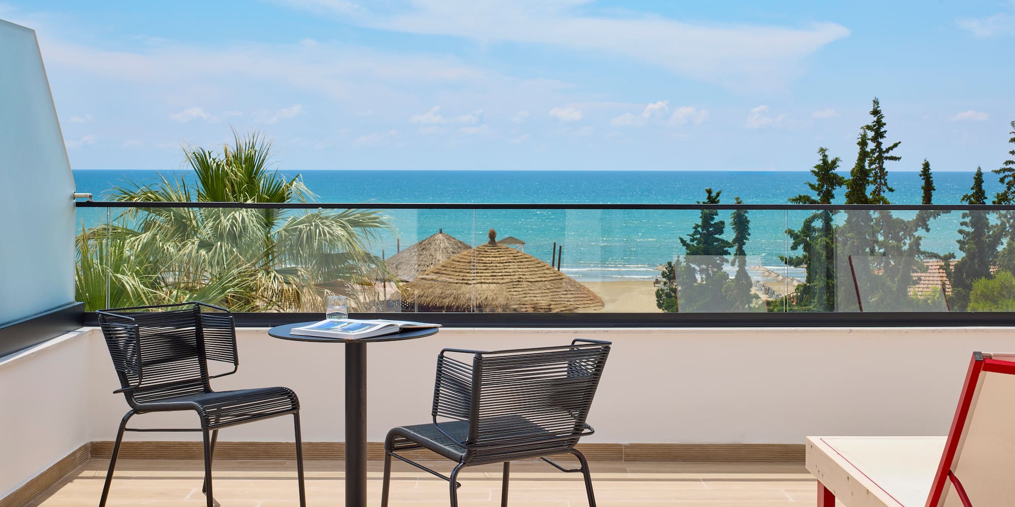 a table and chairs on a balcony overlooking the ocean