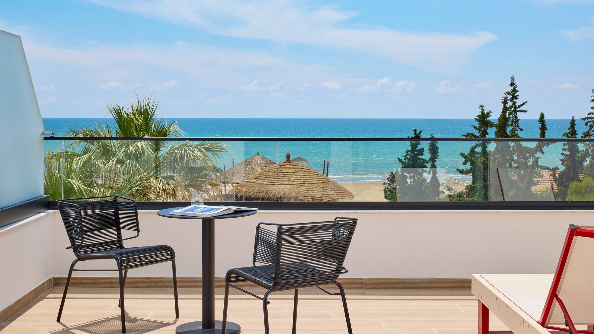 a table and chairs on a balcony overlooking the ocean