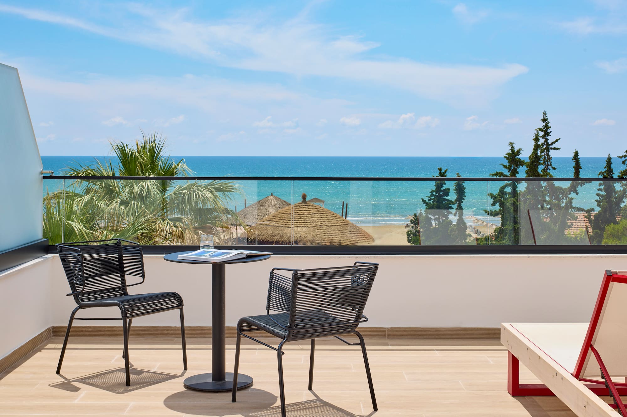 a table and chairs on a balcony overlooking the ocean