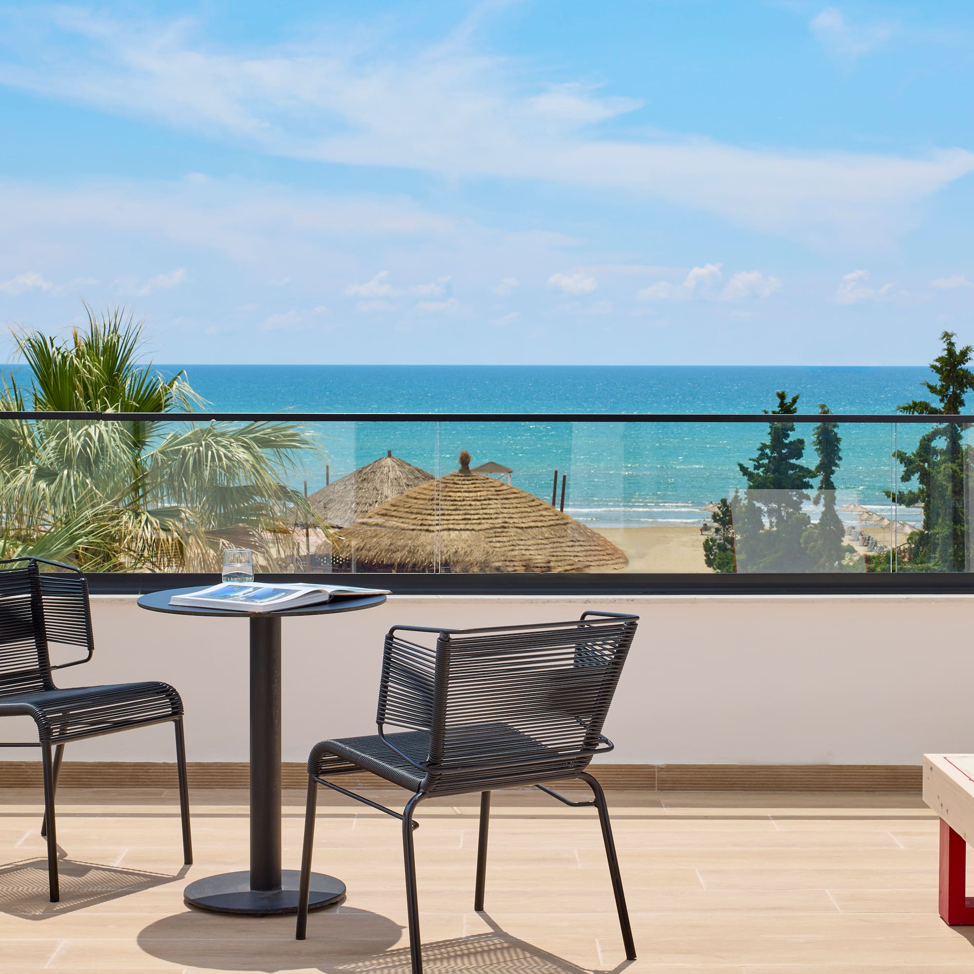 a table and chairs on a balcony overlooking the ocean