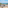 Balcony with ocean view, sandy beach, straw umbrellas, and outdoor seating.