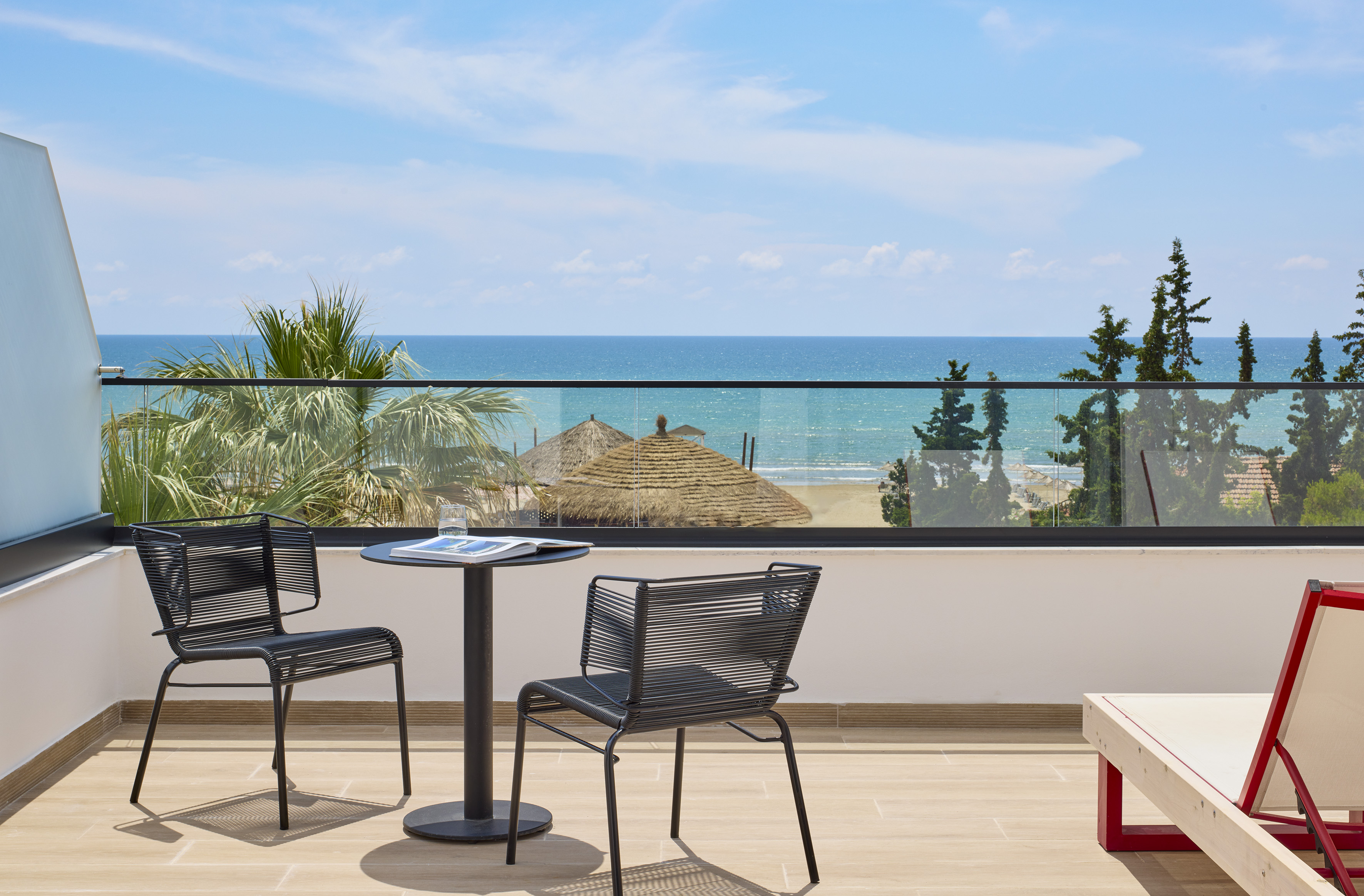a table and chairs on a balcony overlooking the ocean