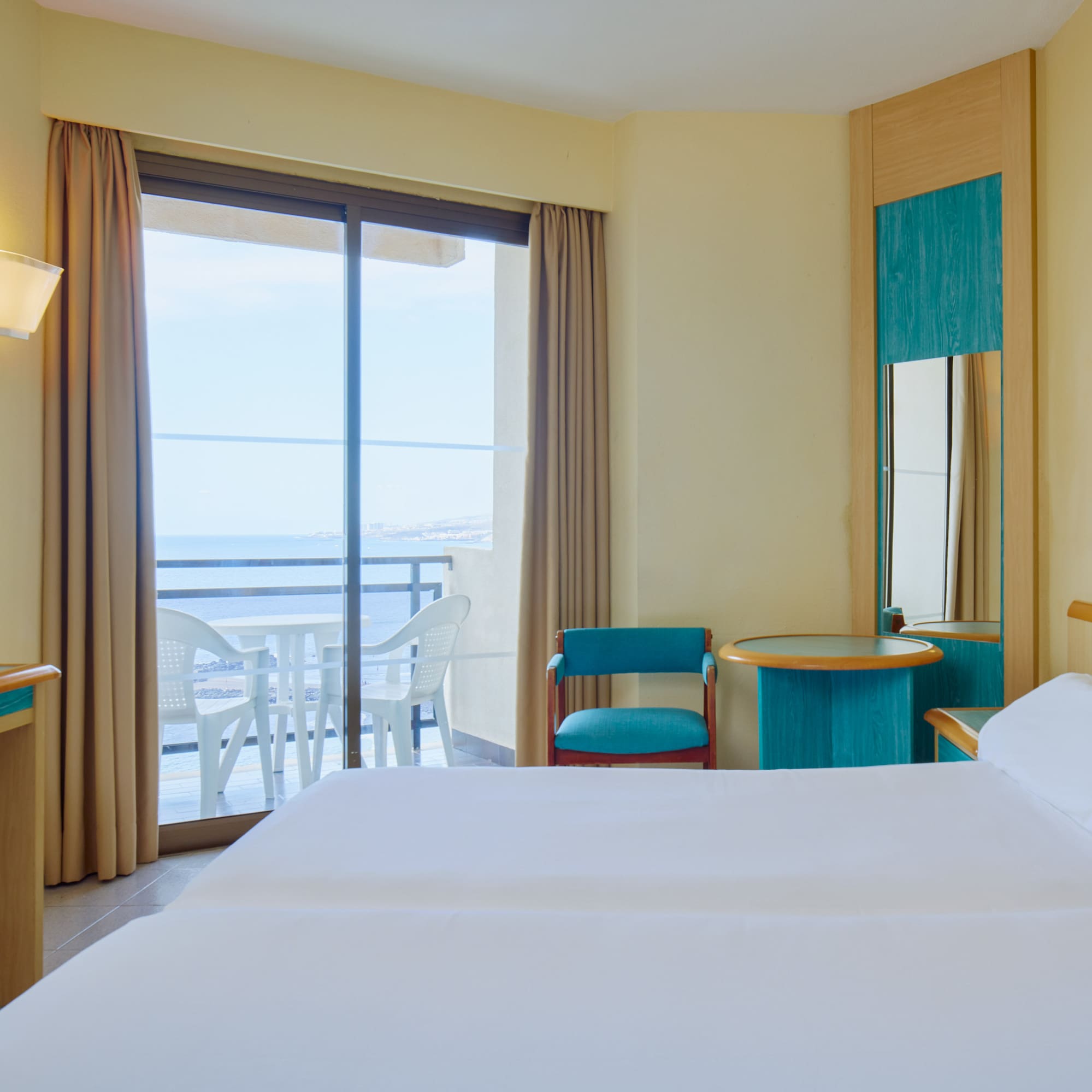 a room with two beds and a table and chairs