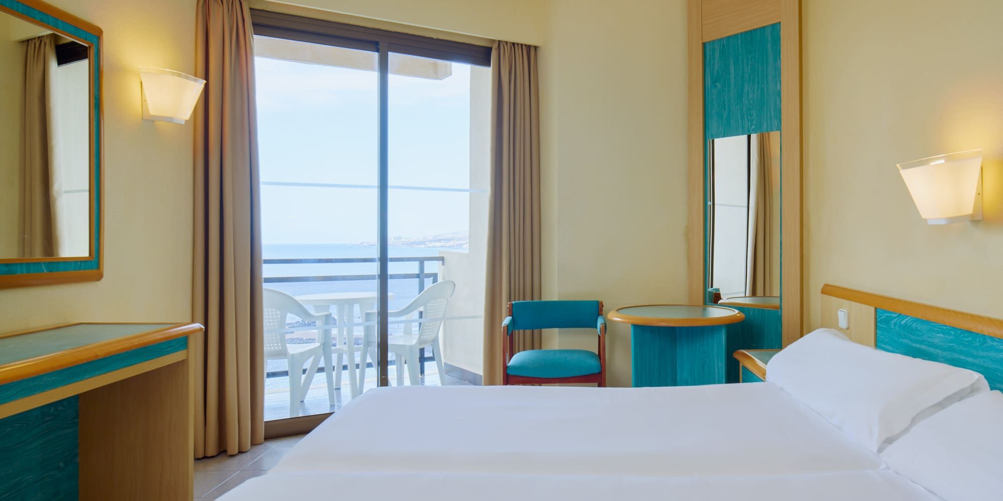 a room with two beds and a table and chairs