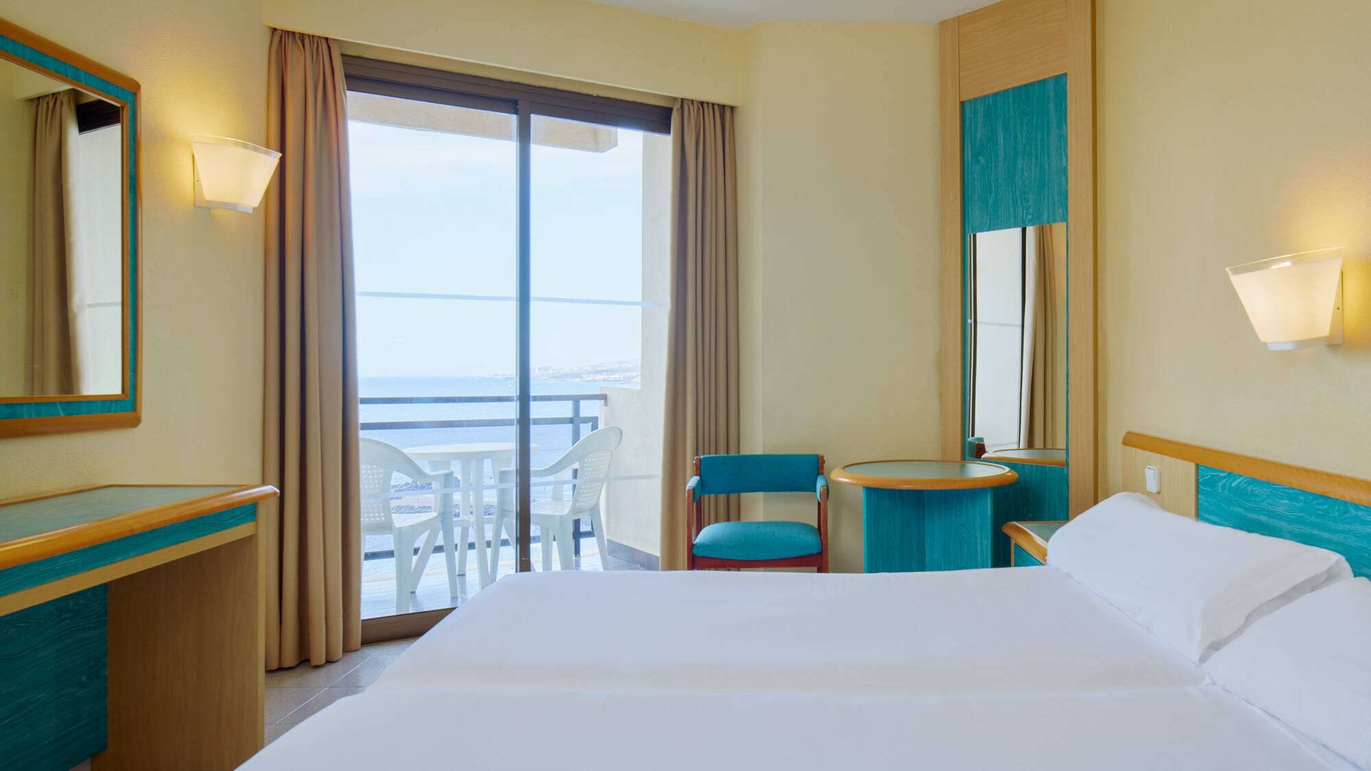 a room with two beds and a table and chairs