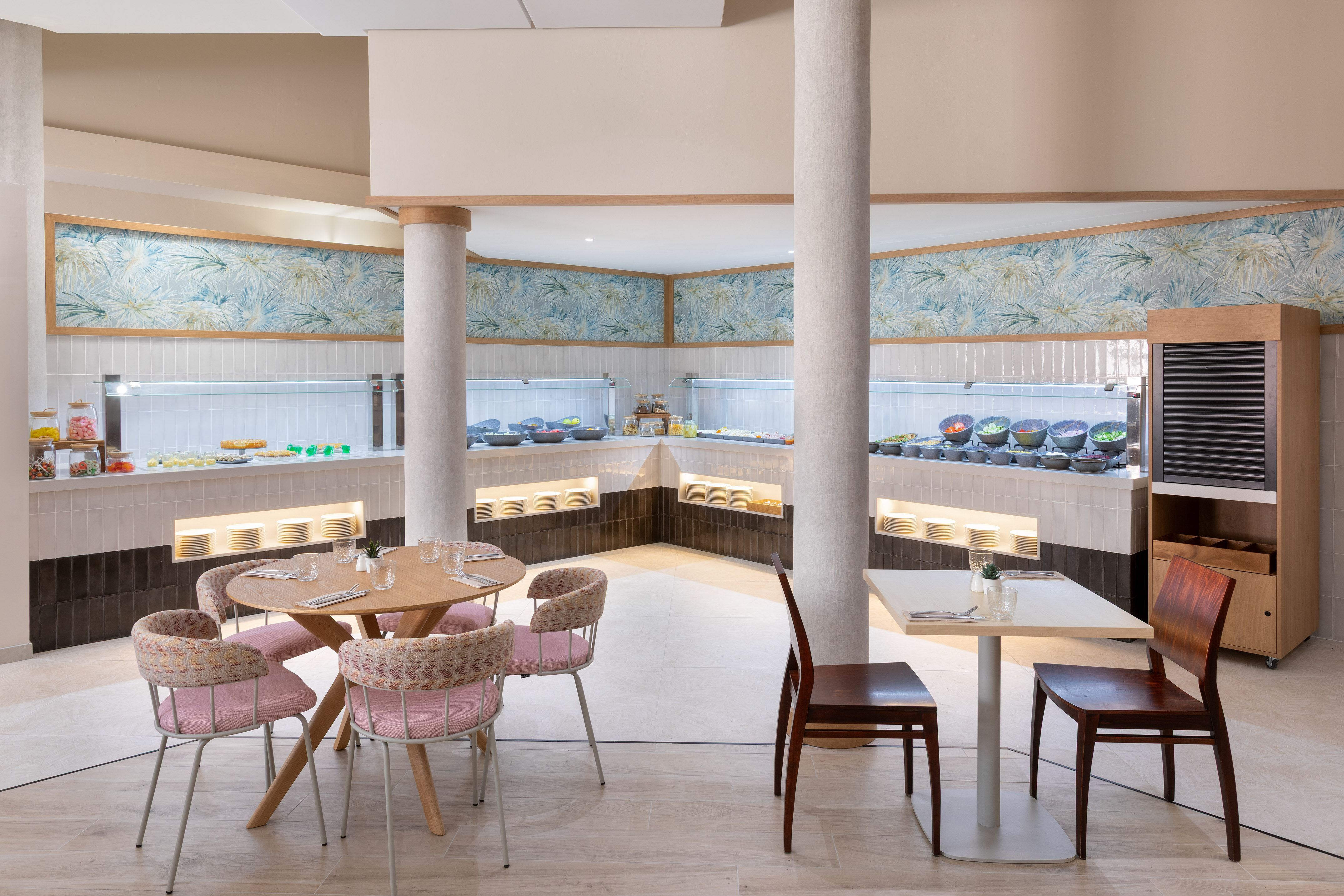 Bright buffet restaurant with fresh food displays, tropical wallpaper, and inviting seating.