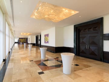 a hallway with marble floor and white tables