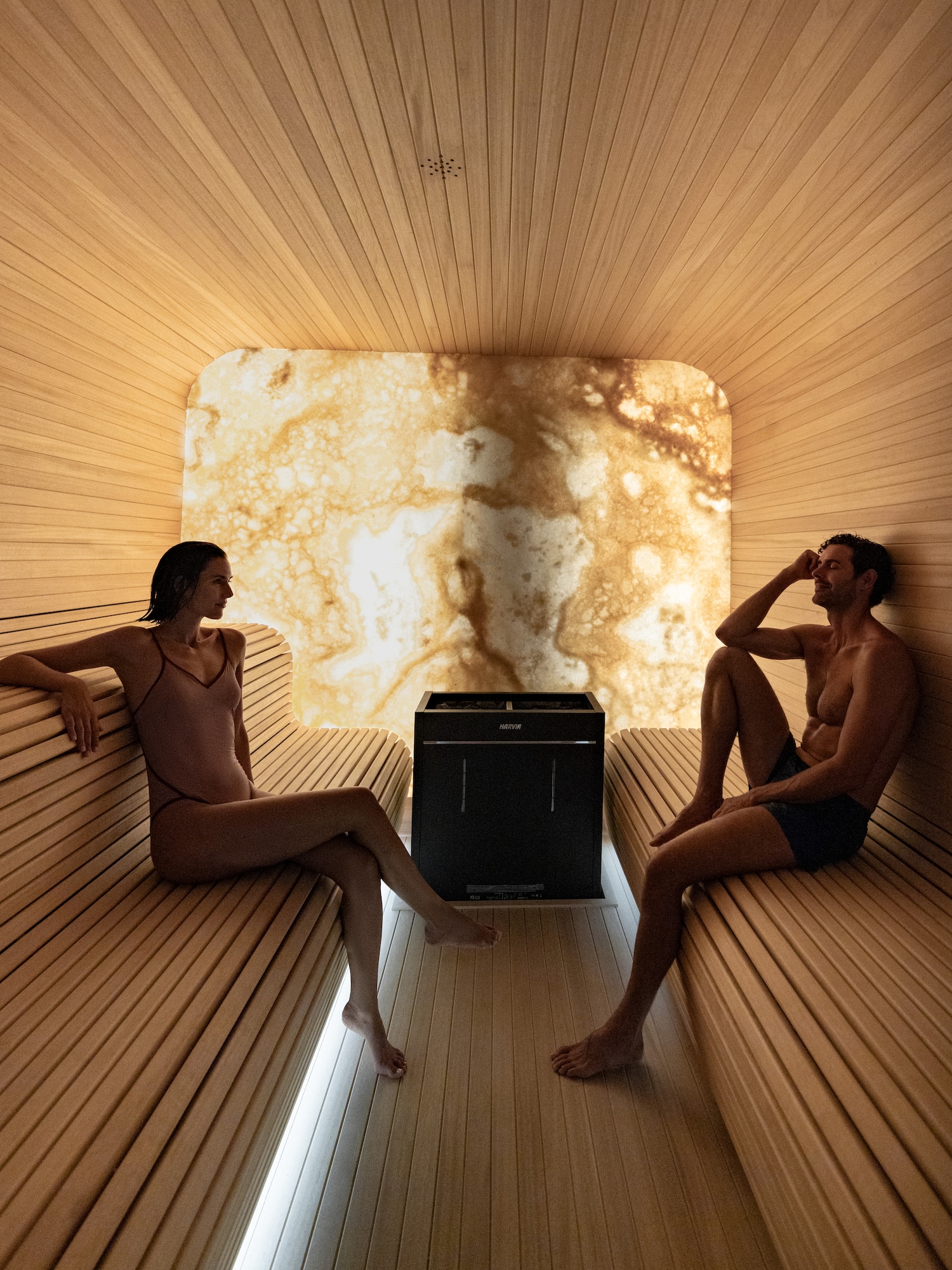 a man and woman sitting in a sauna