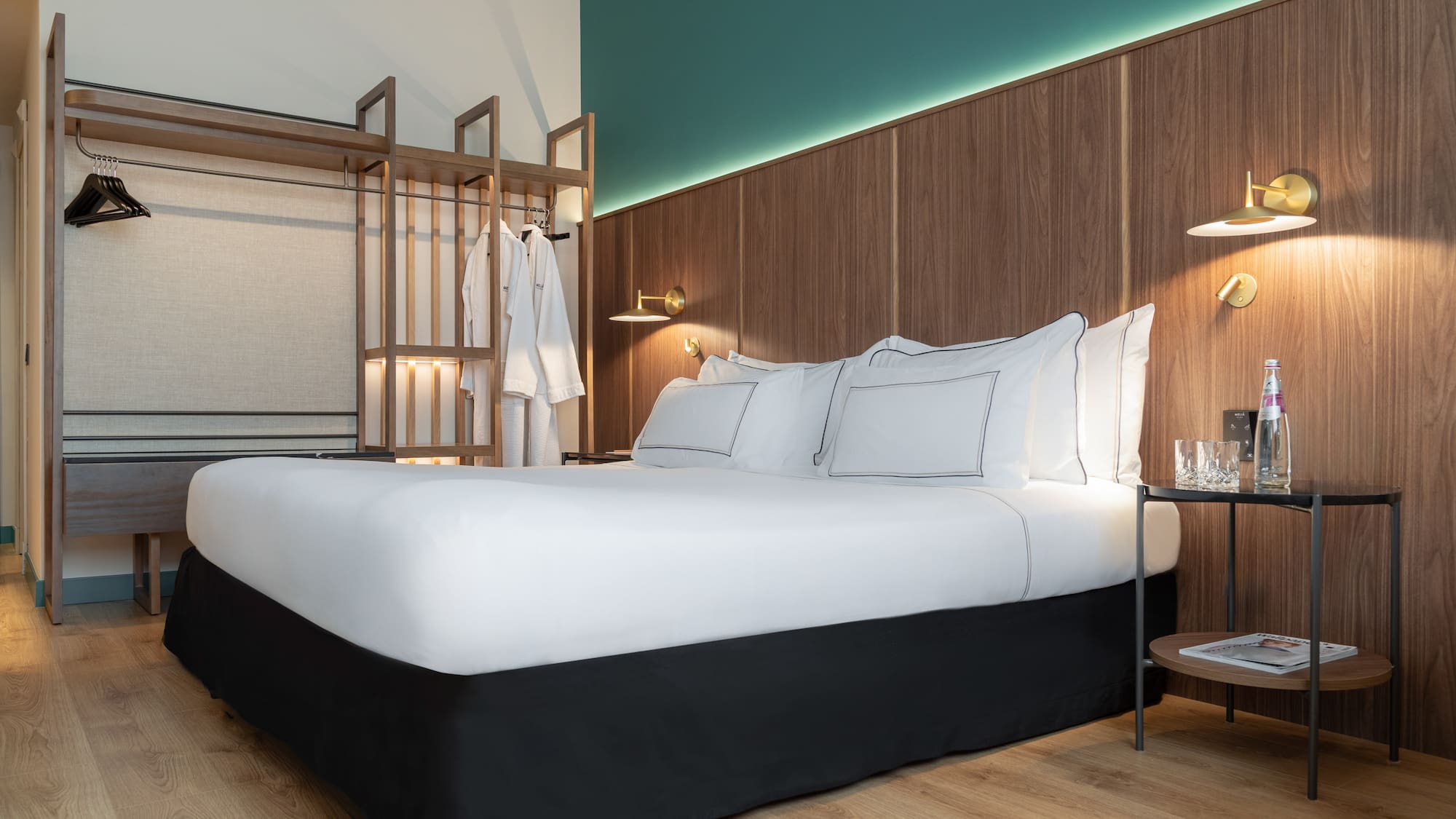 a bed with white sheets and a wood wall