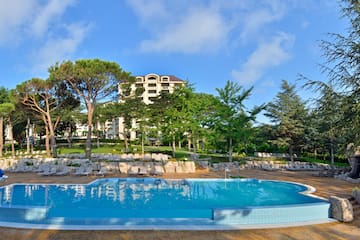 a pool with lounge chairs and trees in the background