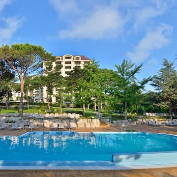 a pool with lounge chairs and trees in the background