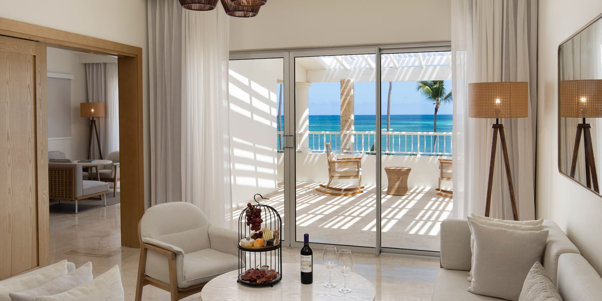 a room with a glass door and a table with a wine bottle