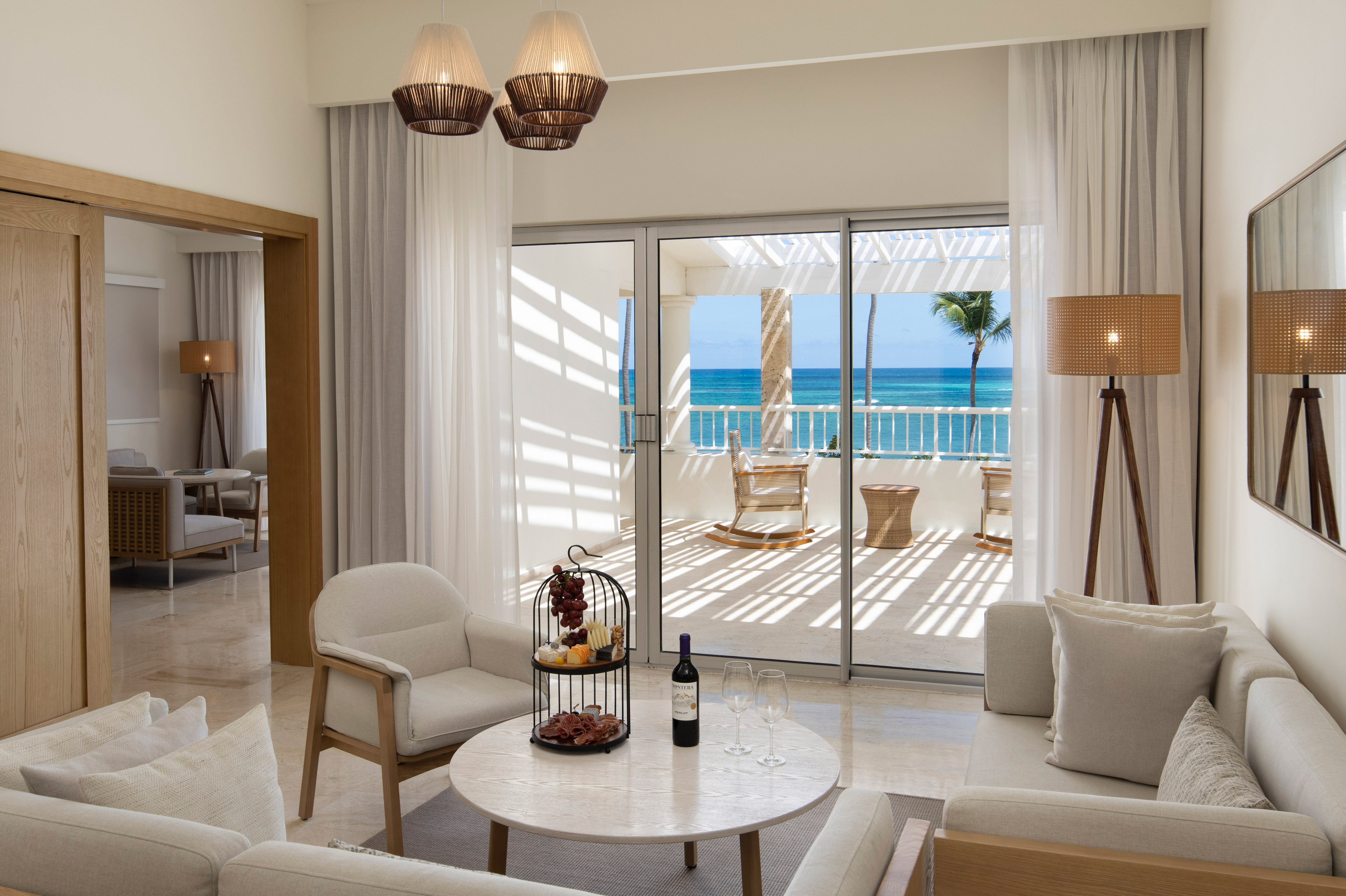 Elegant living room in a tropical suite with ocean view balcony.