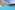 Tropical resort with spacious blue pool, hotel building, and palm trees.