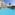 Tropical resort with spacious blue pool, hotel building, and palm trees.