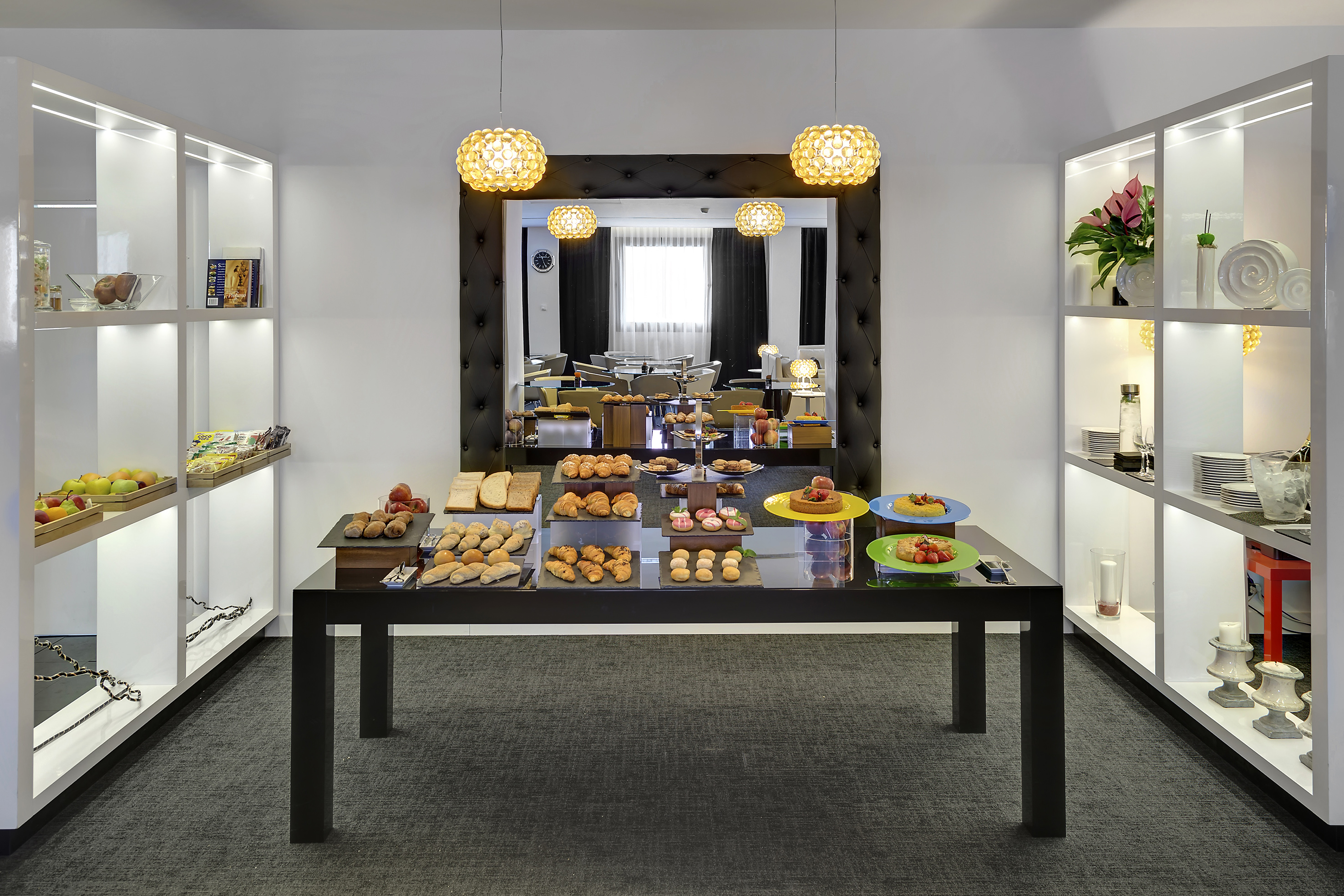 Modern hotel breakfast buffet featuring pastries, bread, and fresh fruit.
