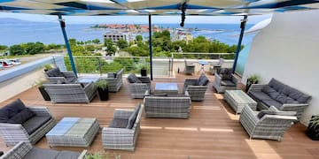a patio area with chairs and a view of the ocean
