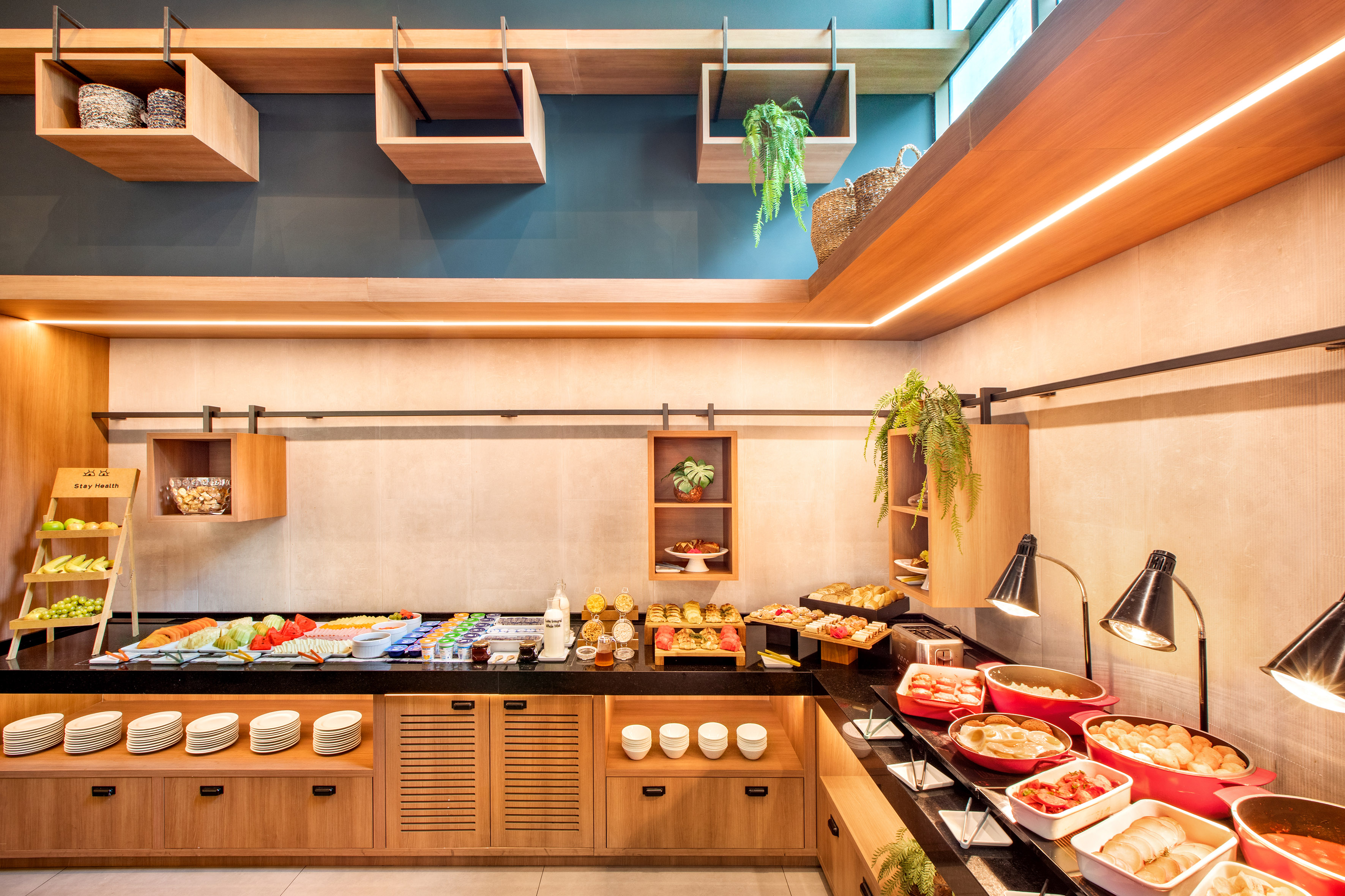 Modern hotel breakfast buffet with fresh fruit, pastries, and hot dishes.
