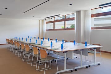 a long conference table with blue bottles and chairs