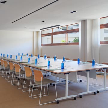 a long conference table with blue bottles and chairs