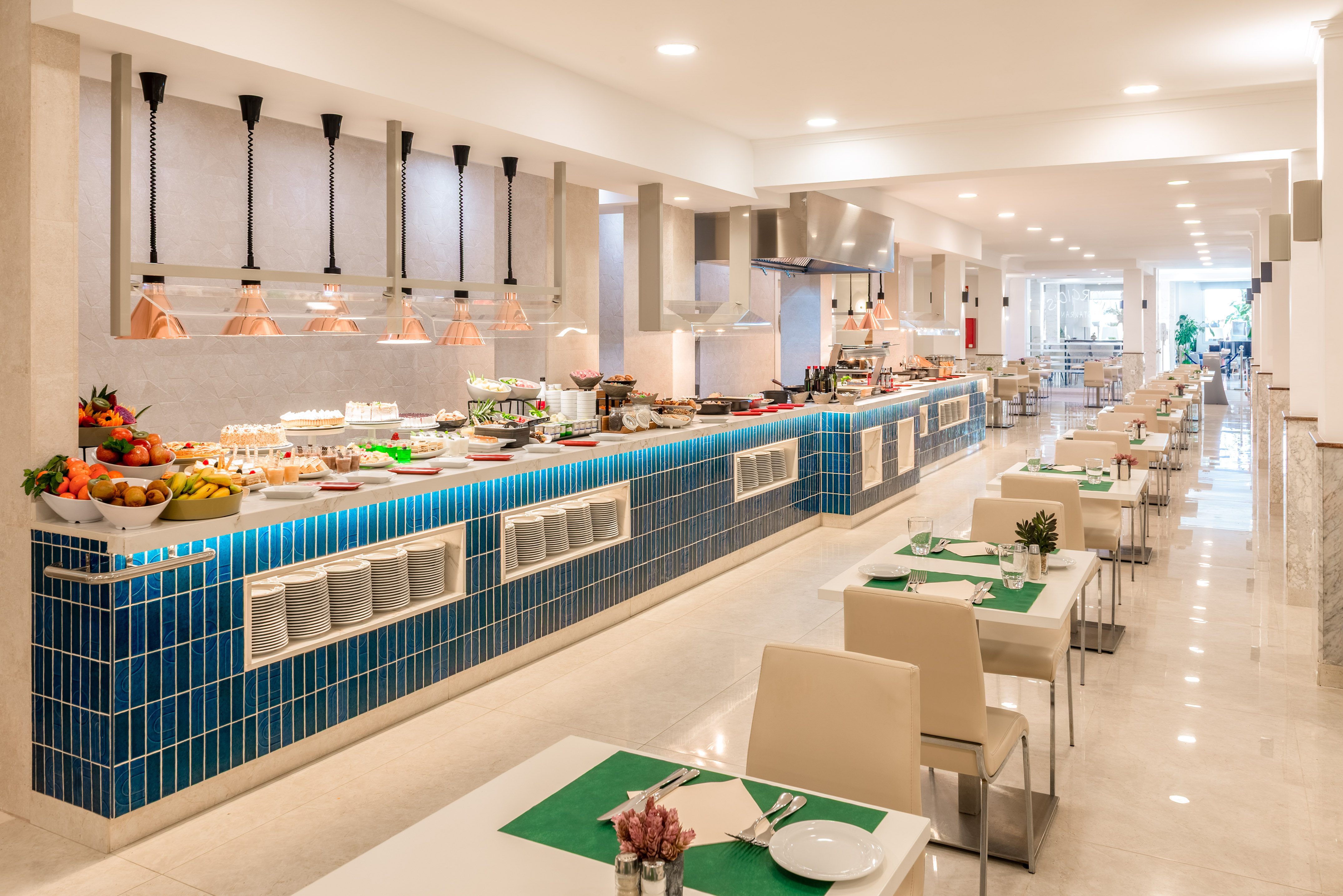 Modern hotel buffet with diverse food selection and dining tables.