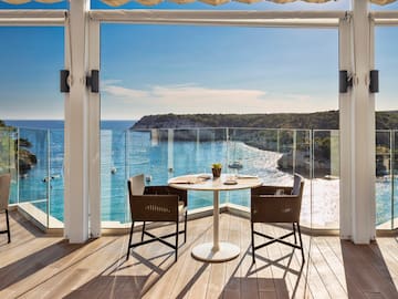 a table and chairs on a deck overlooking a body of water