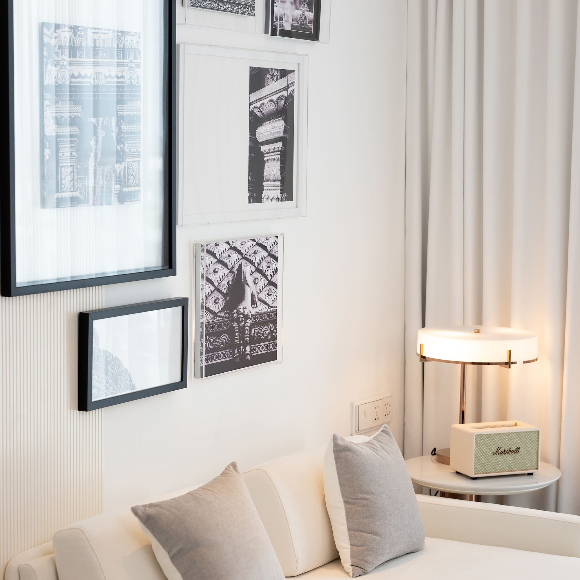 a white couch with pillows and a lamp on a table