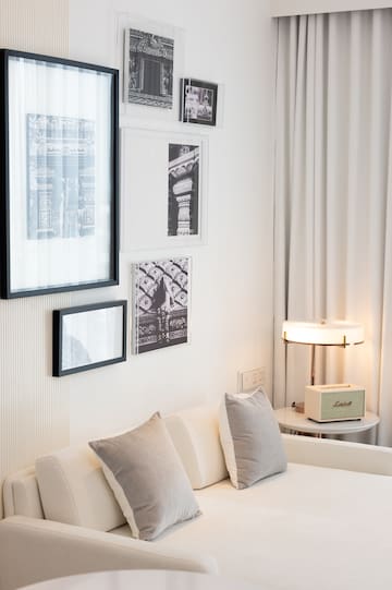 a white couch with pillows and a lamp on a table