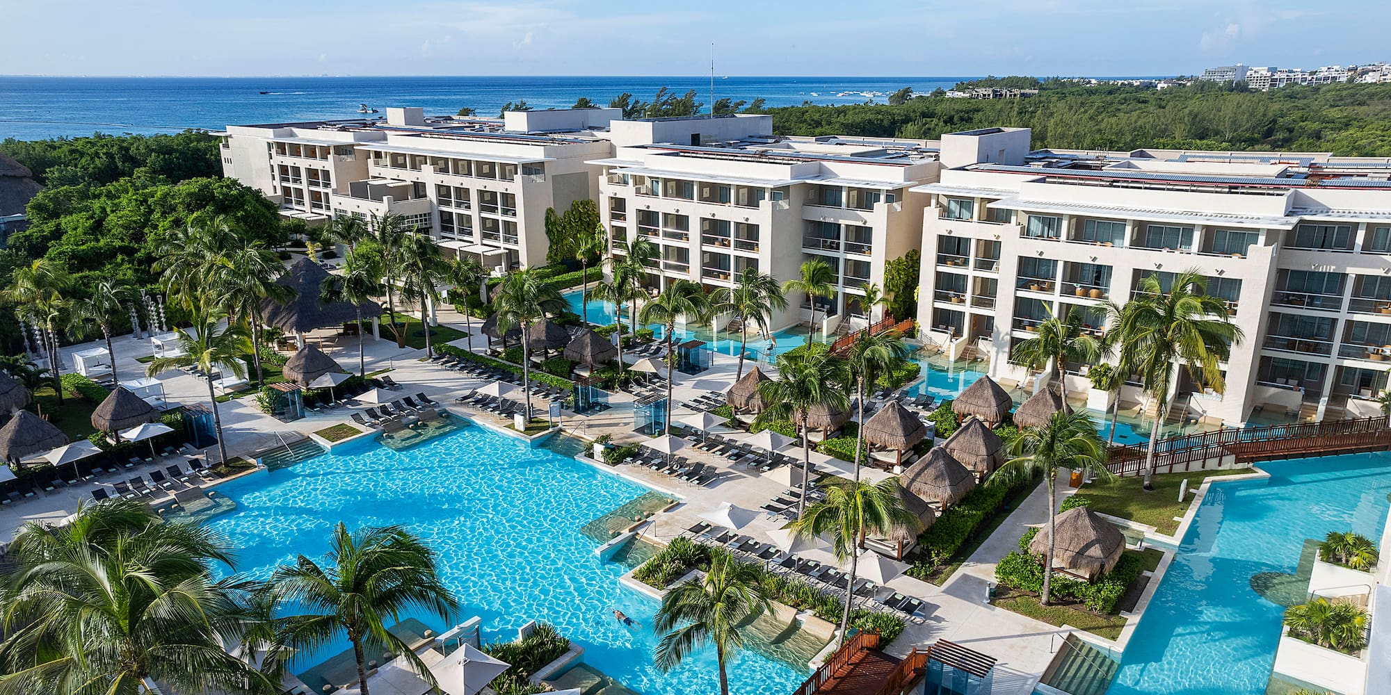 a swimming pool with palm trees and buildings