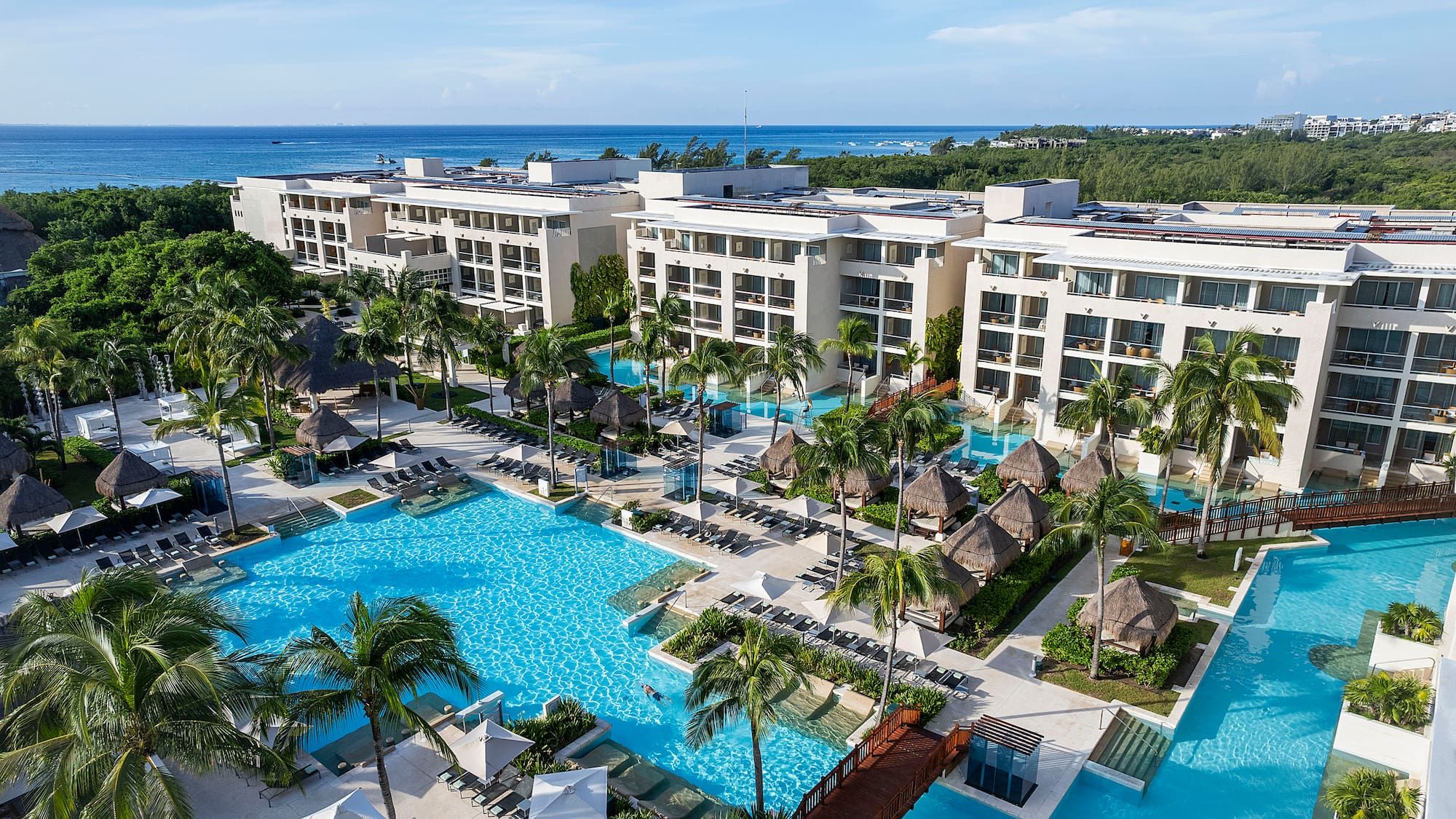 a swimming pool with palm trees and buildings