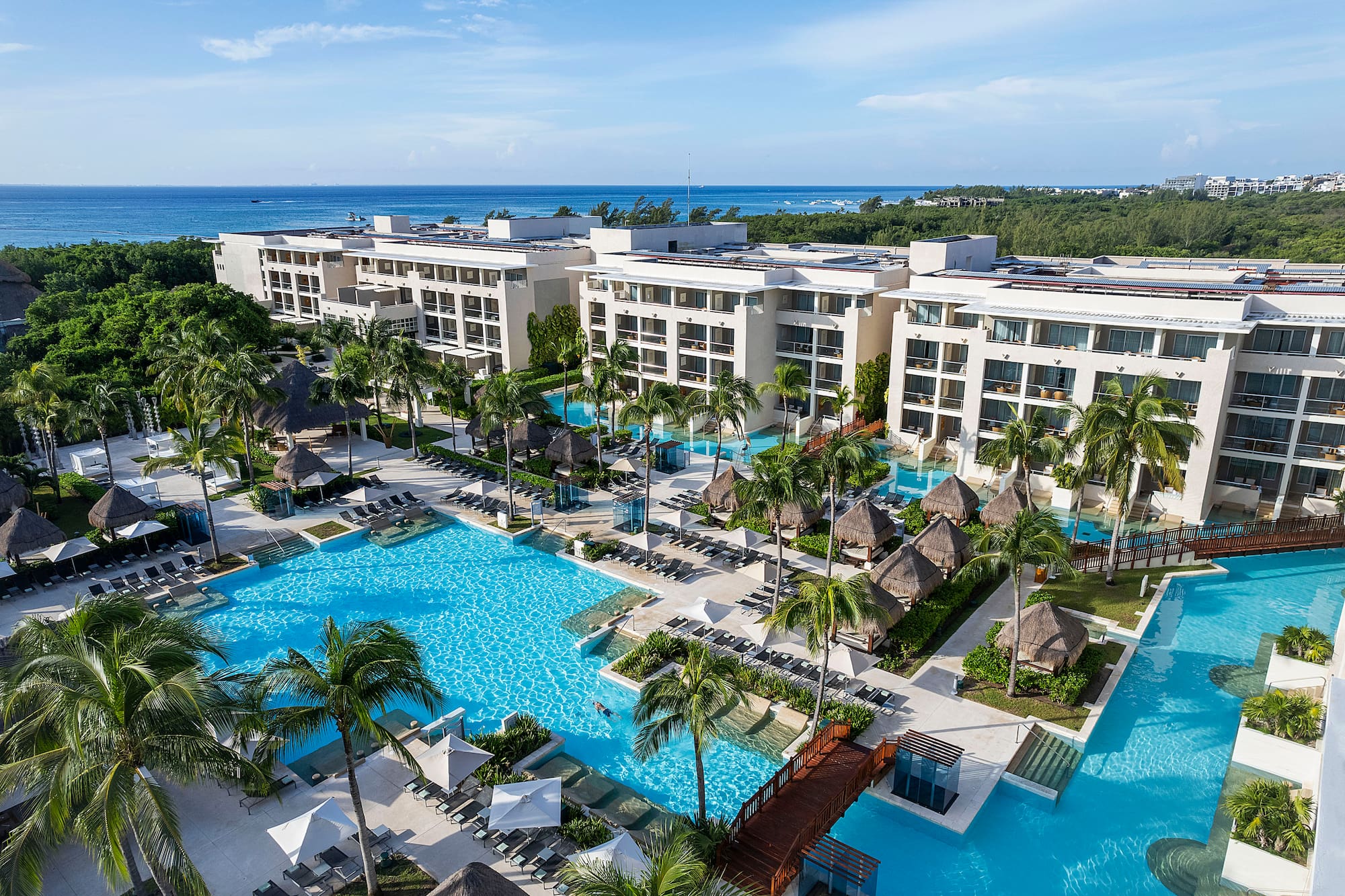 a swimming pool with palm trees and buildings