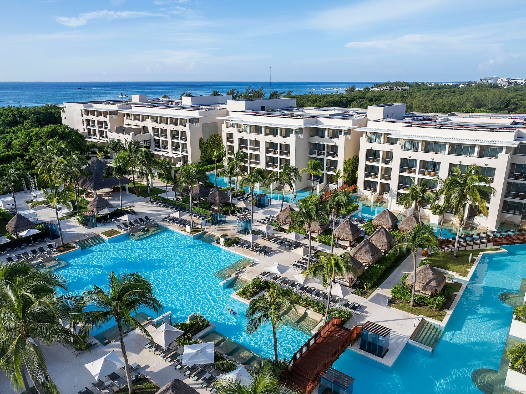 a swimming pool with palm trees and buildings
