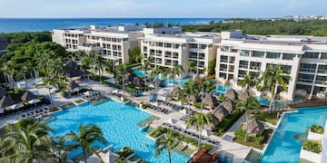a swimming pool with palm trees and buildings