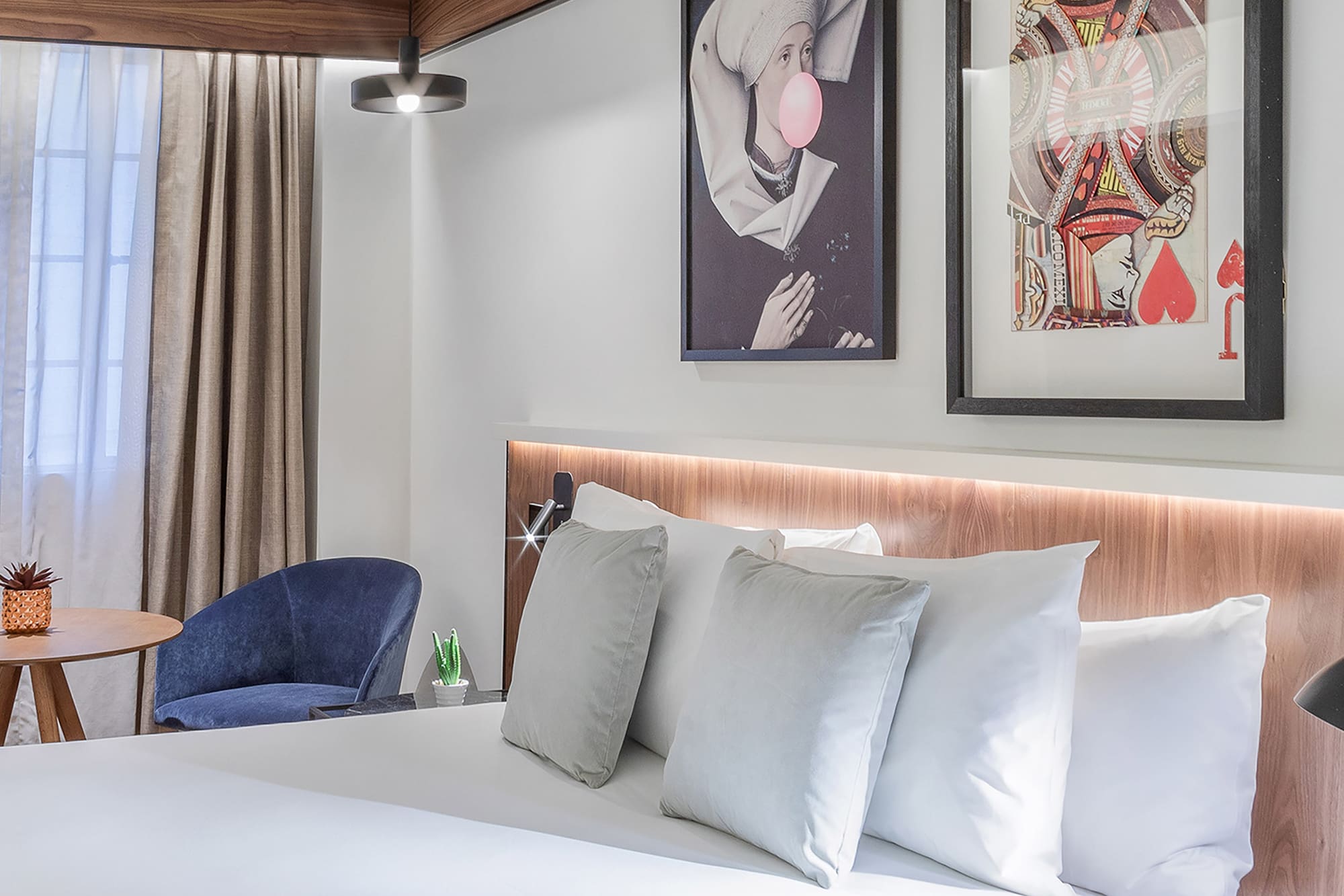 a bed with pillows and a picture on the wall