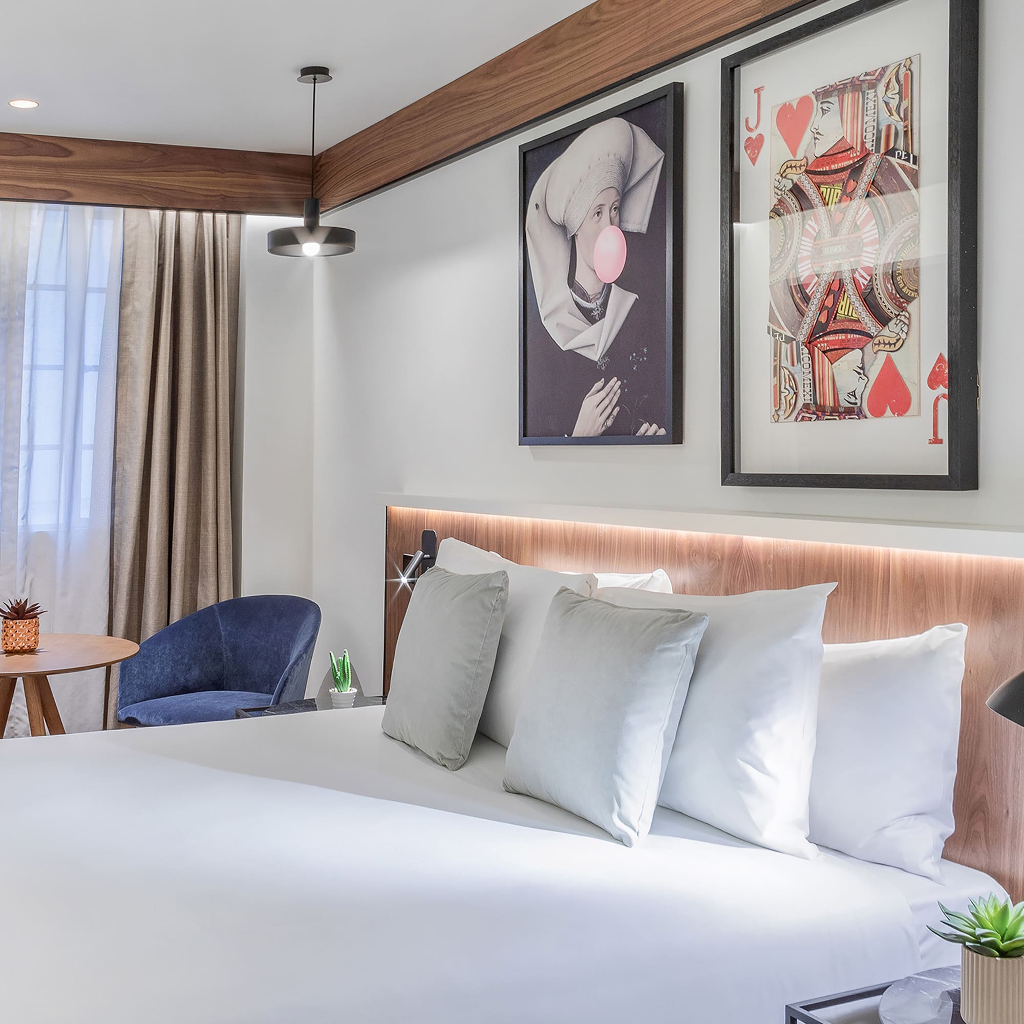 a bed with pillows and a picture on the wall