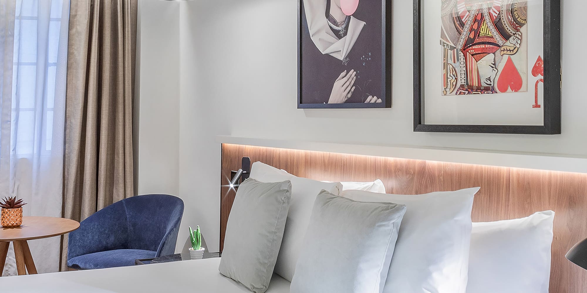 a bed with pillows and a picture on the wall