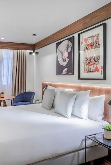 a bed with pillows and a picture on the wall