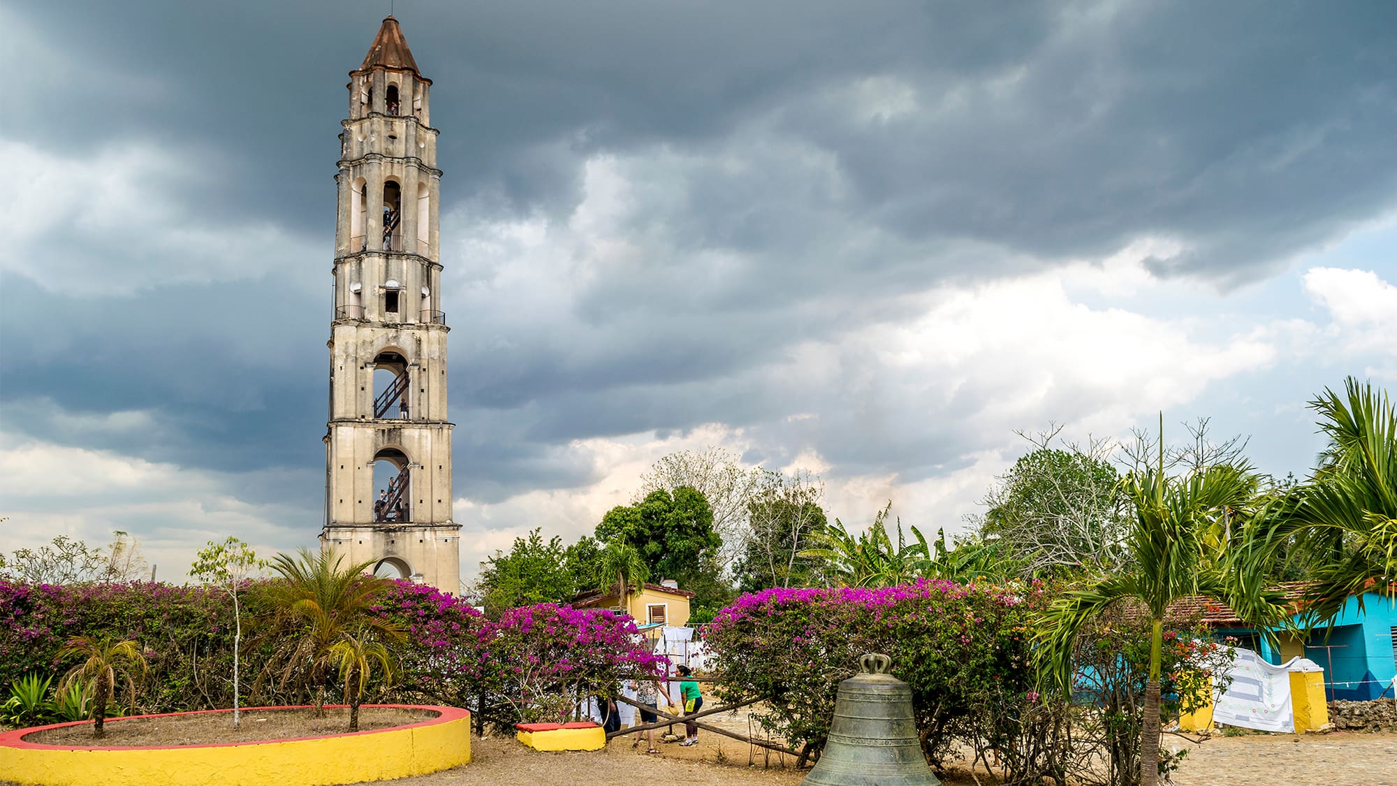 a tall tower with a bell and flowers