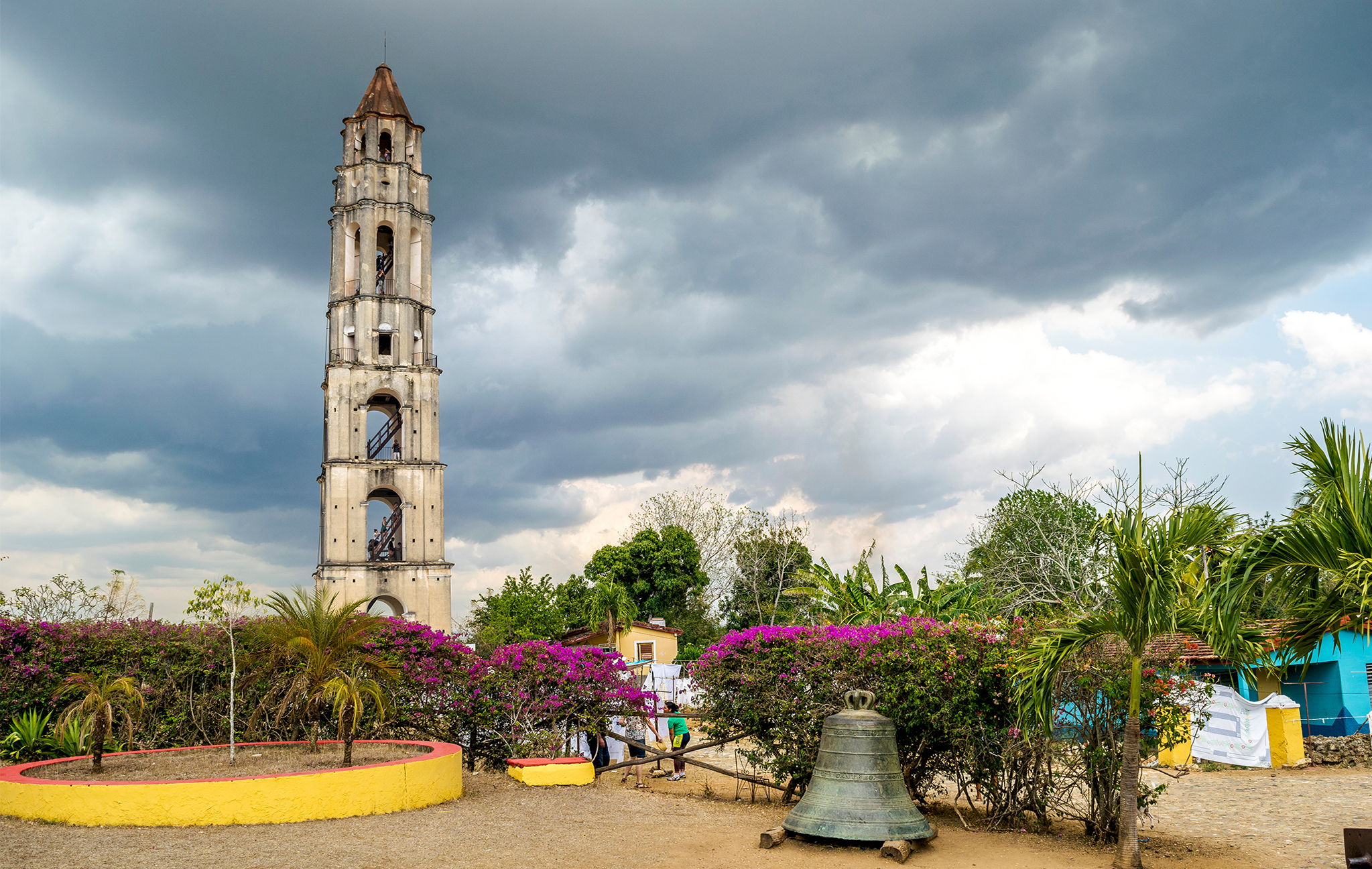 a tall tower with a bell and flowers