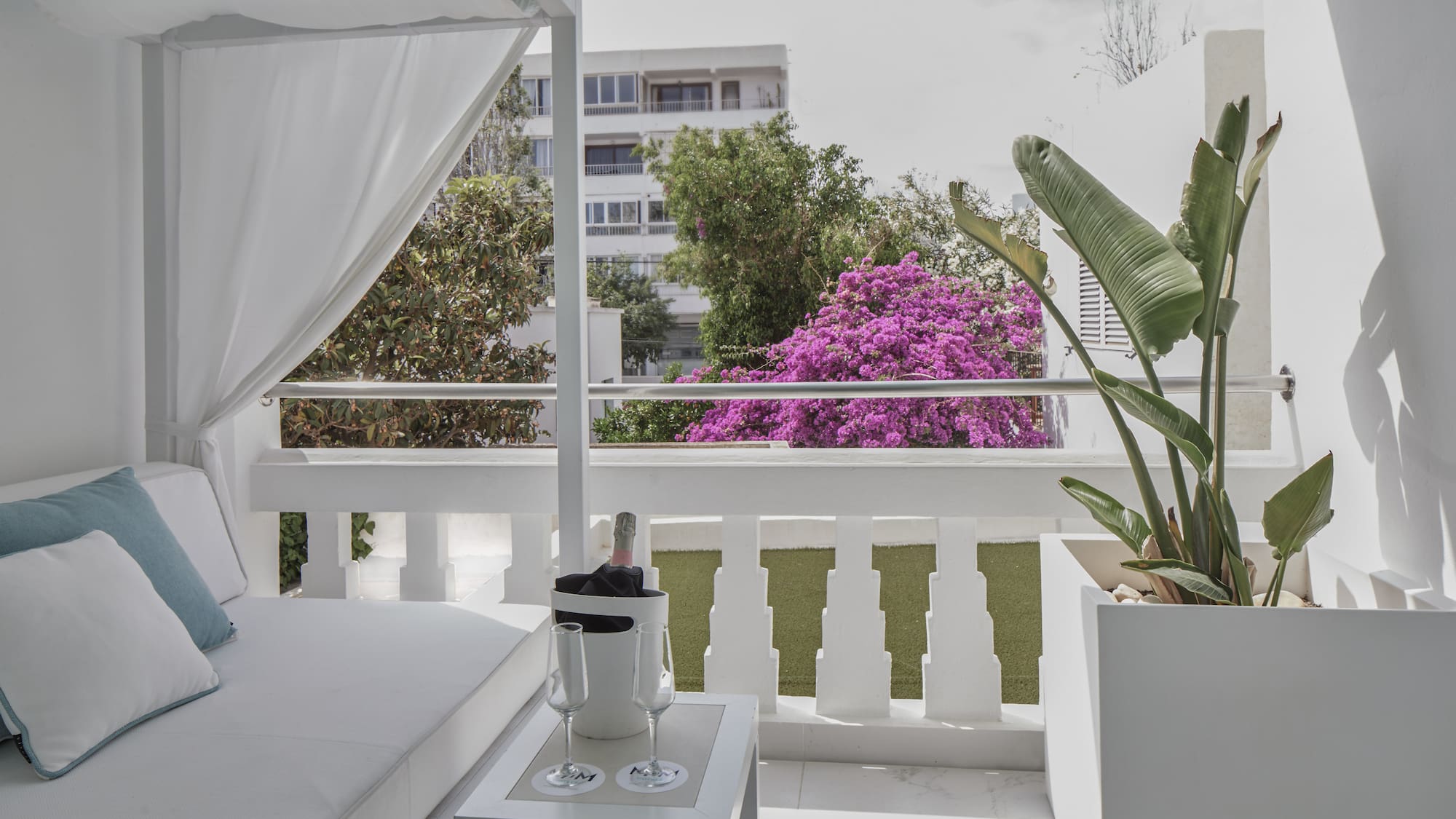 a white patio with a white canopy and a white table and a white chair
