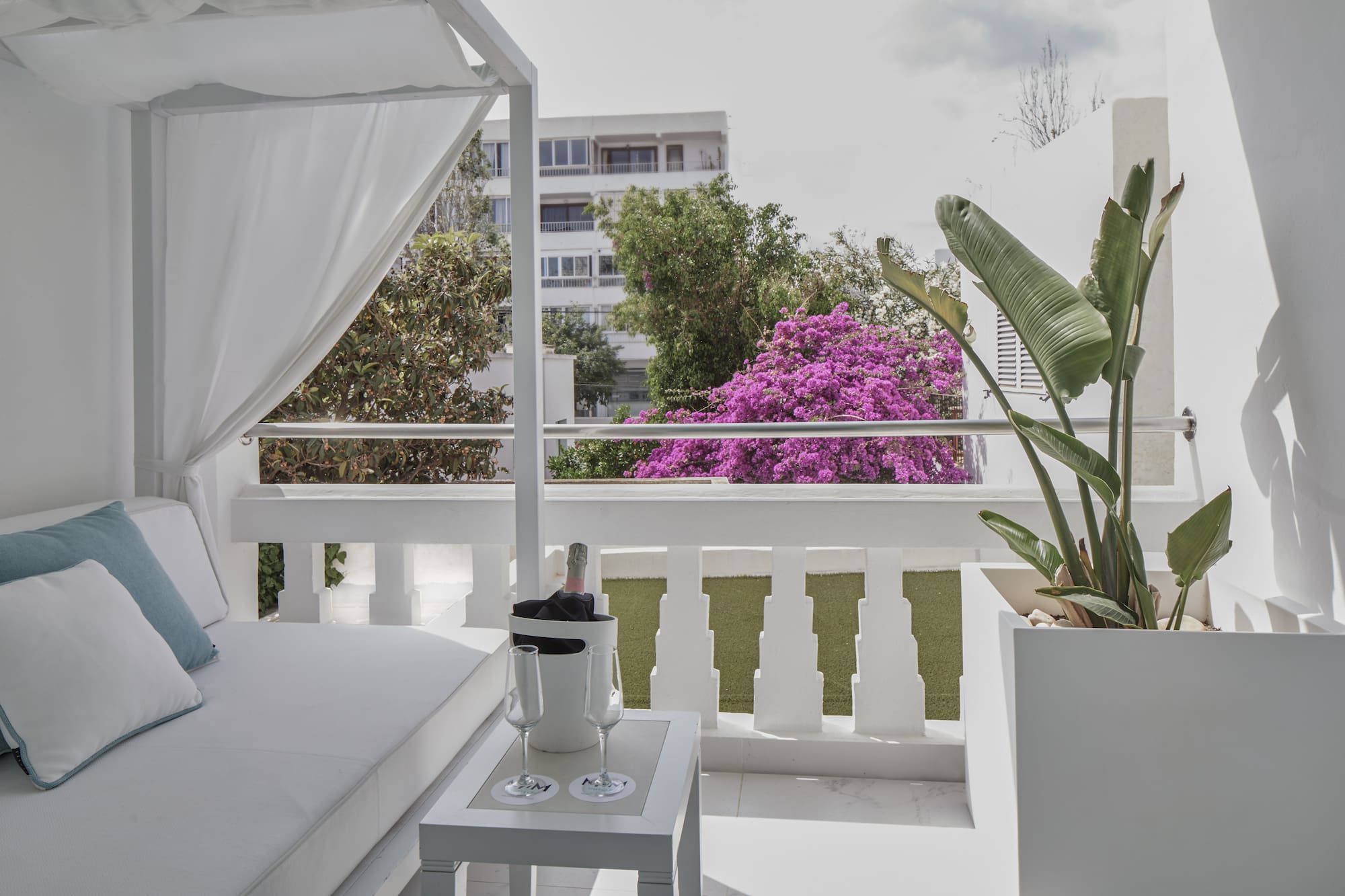 a white patio with a white canopy and a white table and a white chair
