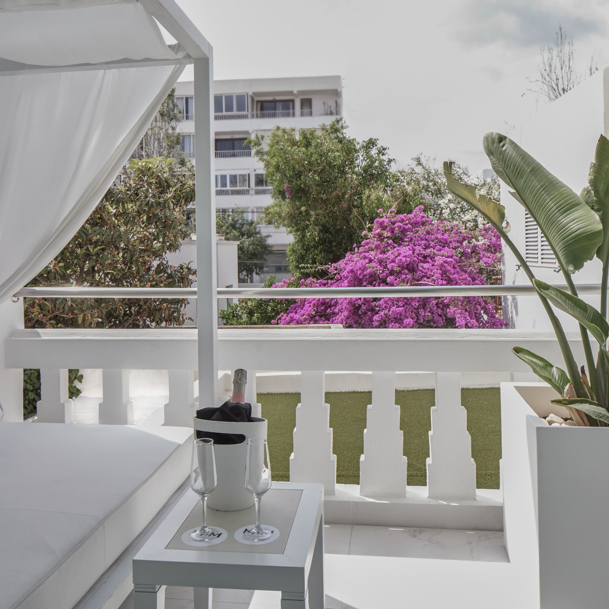 a white patio with a white canopy and a white table and a white chair
