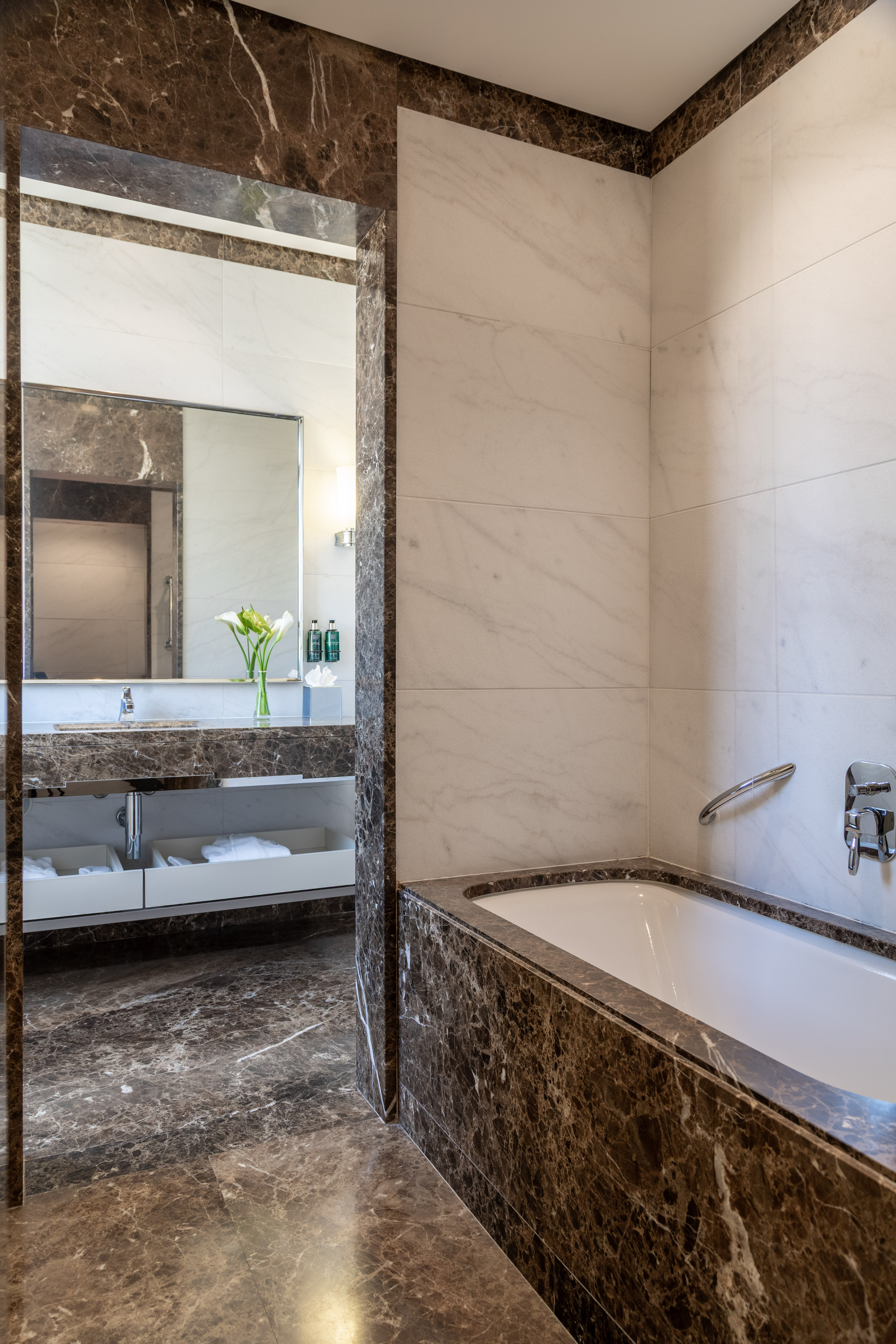 Luxury bathroom with brown marble floors, white walls, modern bathtub, and vanity. - Junior Suite مع تراس - Meliá Genova, جنوة