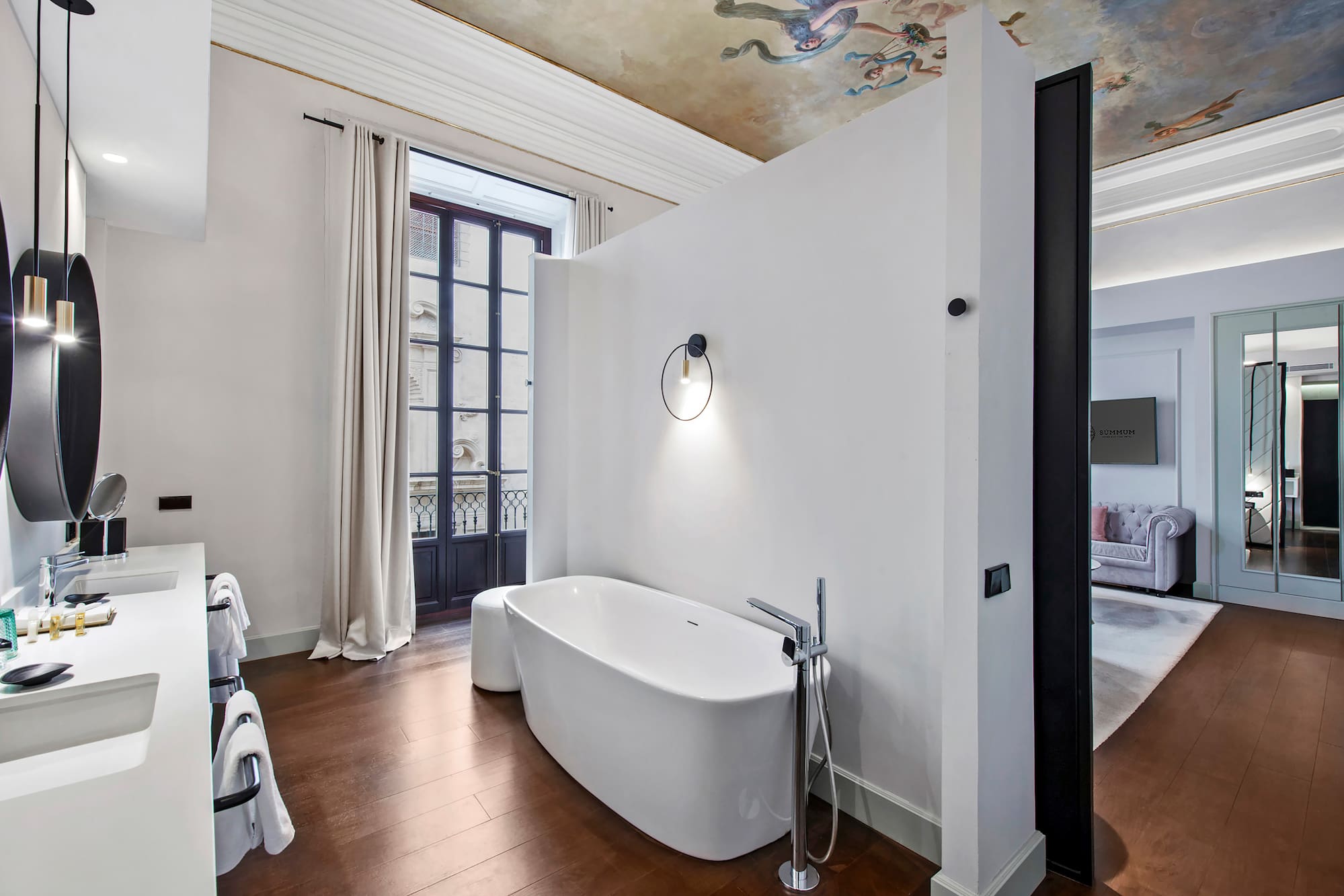 a bathroom with a tub and a wood floor