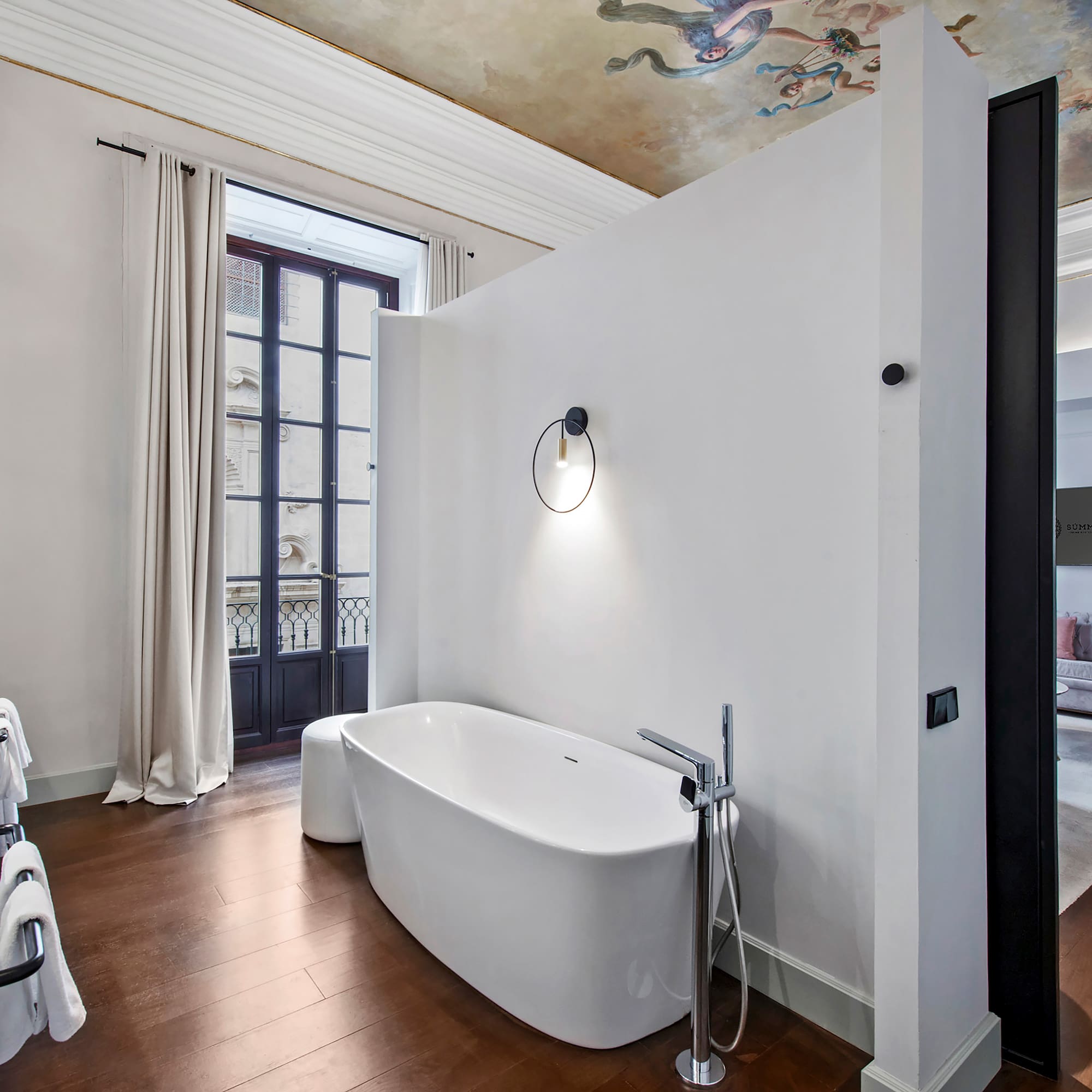 a bathroom with a tub and a wood floor