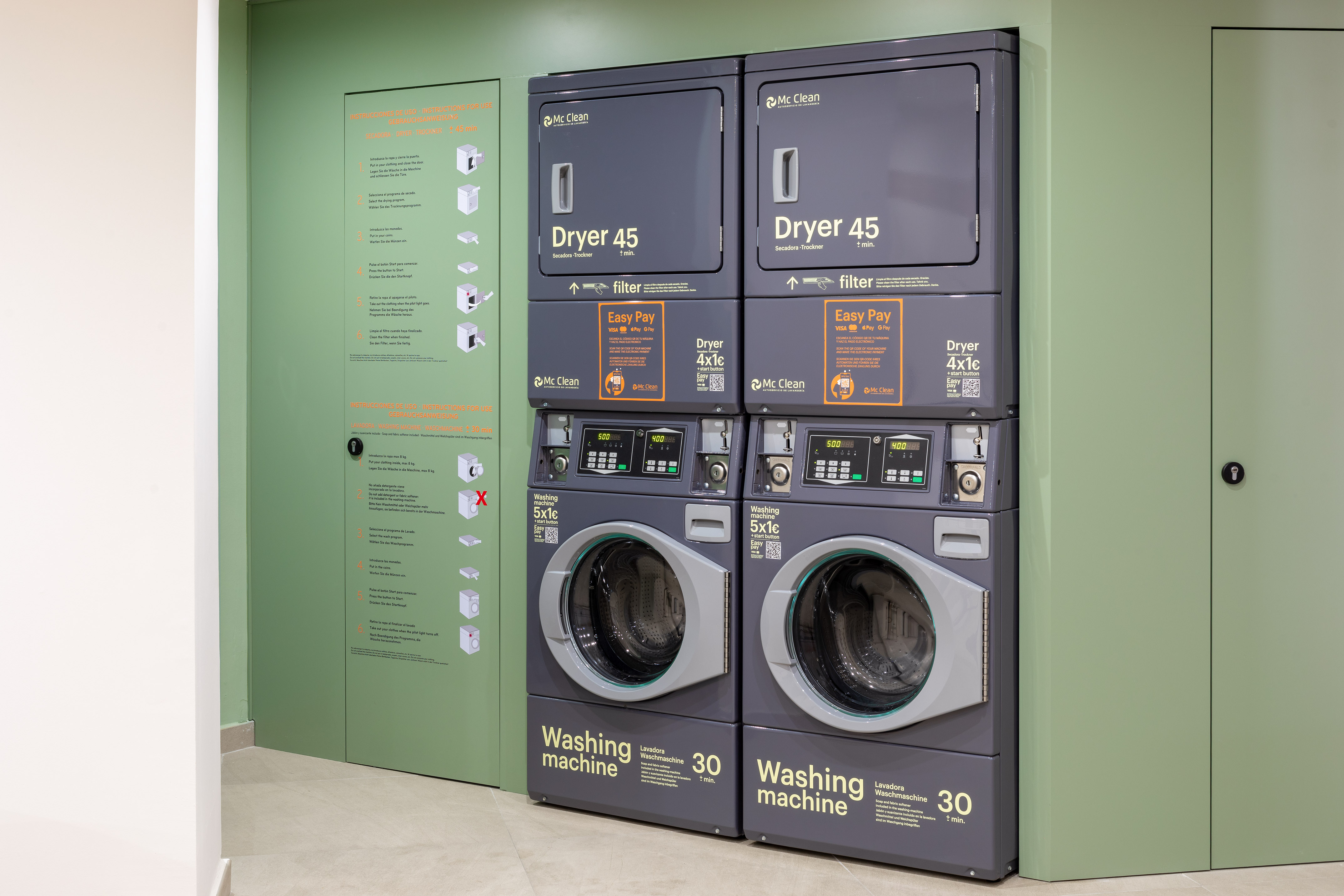 Stacked Mc Clean commercial washers and dryers in a self-service laundromat.
