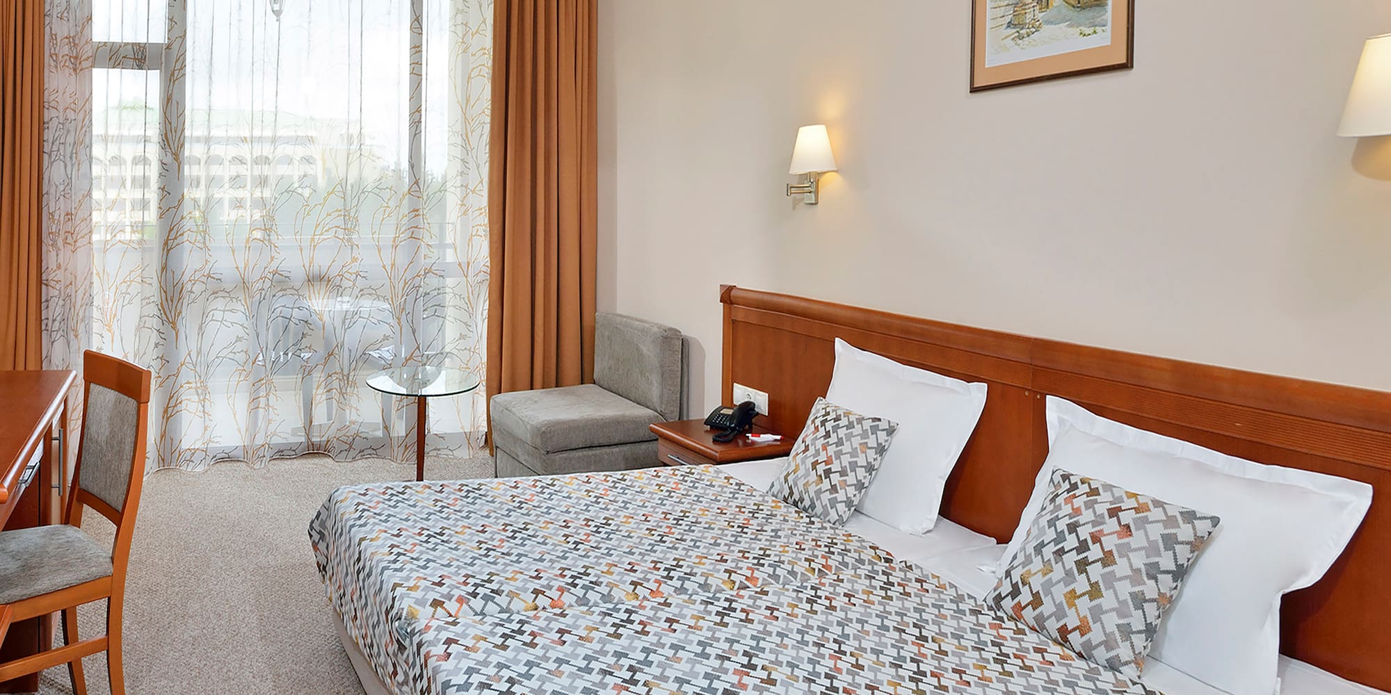 a bed with a patterned bedding and a table in a room
