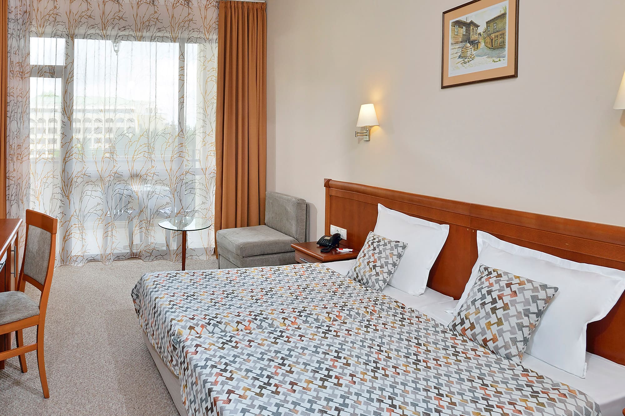 a bed with a patterned bedding and a table in a room